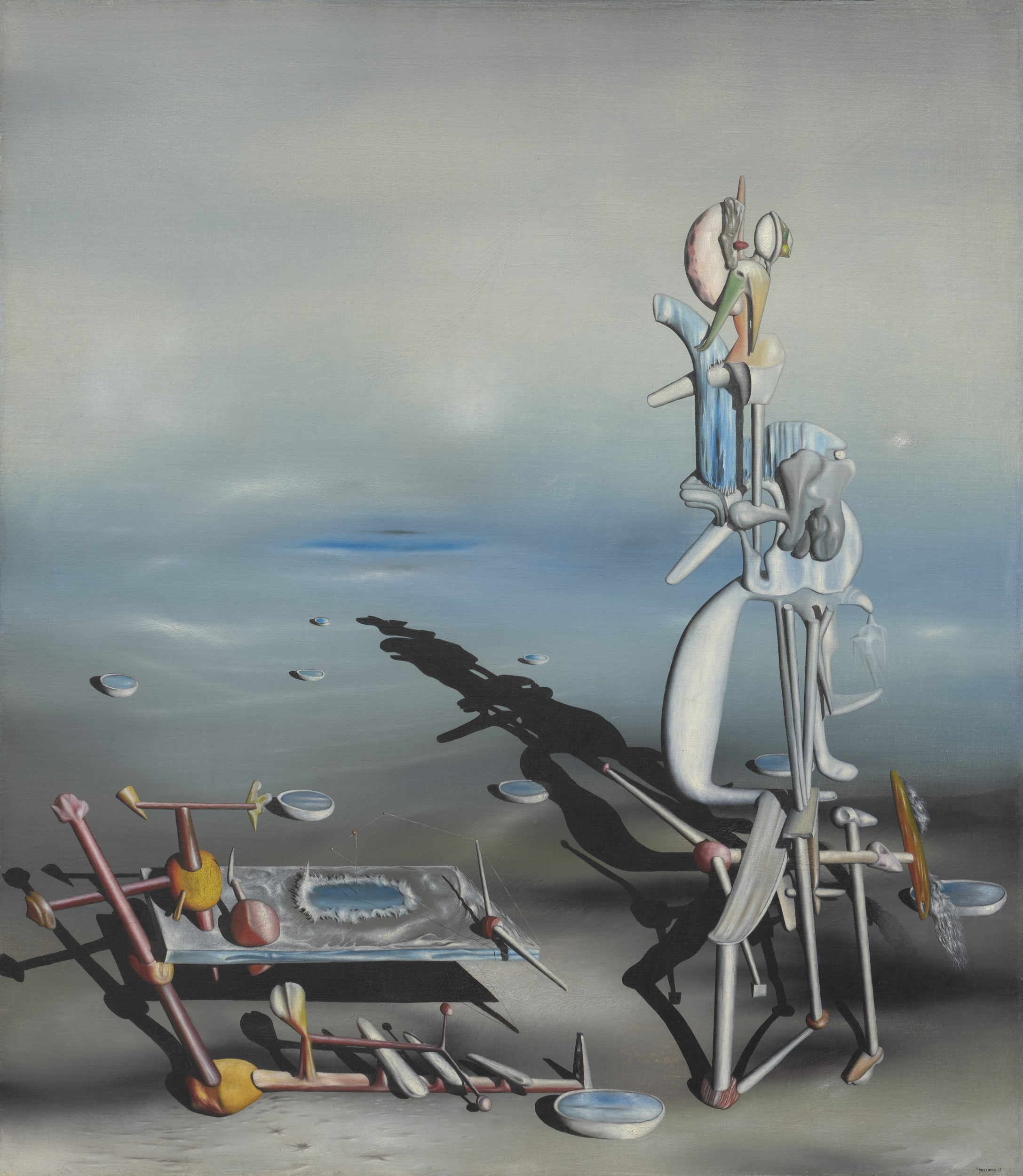 Tanguy's Indefinite Divisibility: smooth white, grey and coloured forms, some upright like bones, one floating, on a pale plain that melts into a clear sky, with crisp shadows