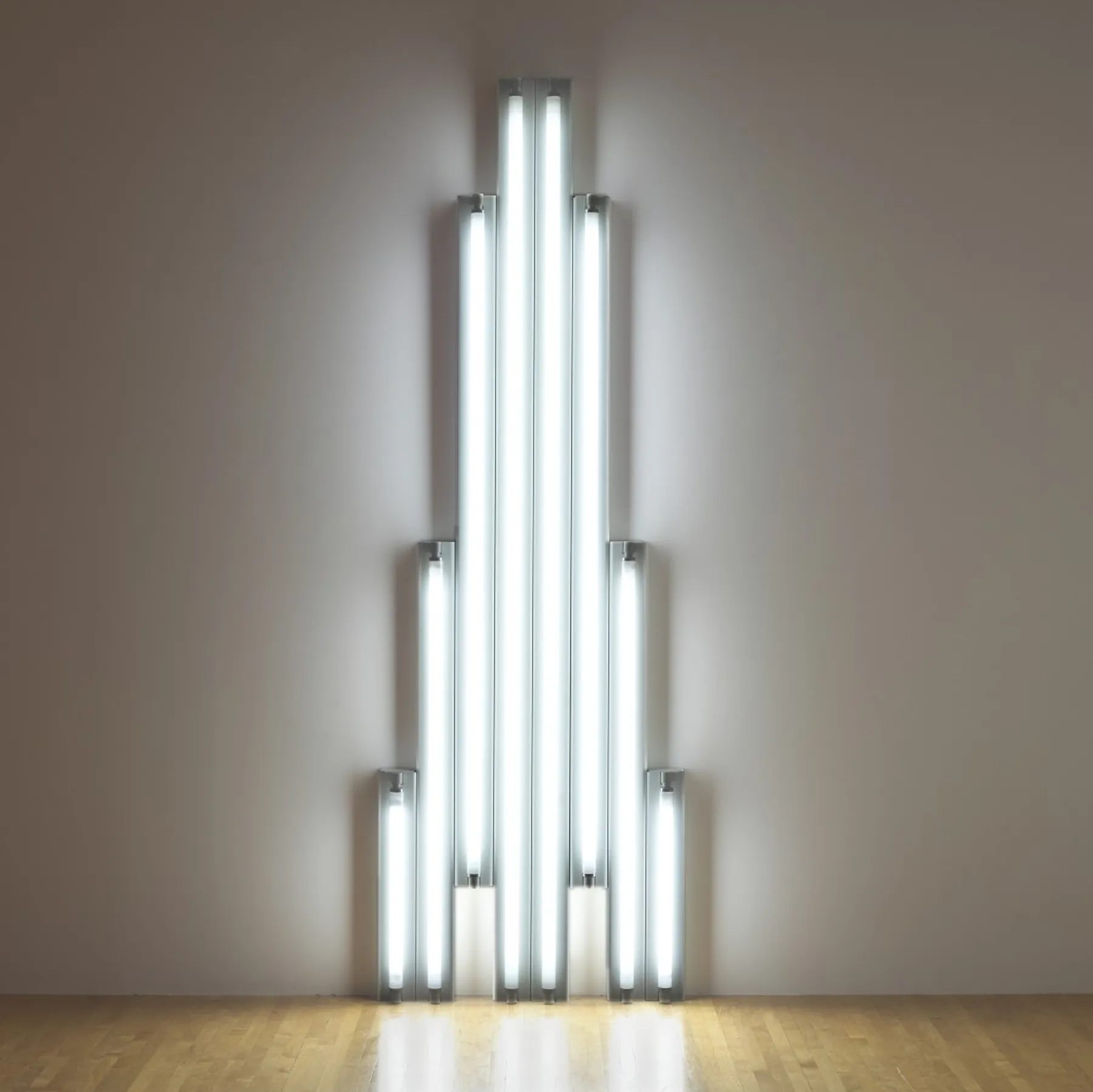Seven white fluorescent tubes ascend diagonally, their cold glow evoking Vladimir Tatlin’s unbuilt Monument to the Third International (1920) a Soviet spiral meant to dwarf the Eiffel Tower.
